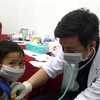 Bác sỹ khám bệnh cho trẻ nhỏ tại xã Trà Leng. (Ảnh: Trịnh Bang Nhiệm/TTXVN) 