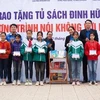 Trao tặng biểu trưng Tủ sách Đinh Hữu Dư cho trường THCS Trần Kim Xuyến. (Ảnh: Hoàng Ngà/TTXVN) 