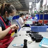 Công nhân hoàn thiện linh kiện giảm chấn băng cao su kỹ thuật cao tại nhà máy ở Đồng Nai. (Ảnh: Minh Hưng/TTXVN) 