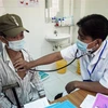 Bác sỹ Danh Ngọc Châu khám bệnh cho người dân tại Phòng khám Trung tâm Y tế huyện Châu Thành. (Ảnh: Hồng Đạt/TTXVN) 