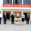 Trao tặng lẵng hoa của Thủ tướng Chính phủ Nguyễn Xuân Phúc chúc mừng các chiến sỹ áo trắng đang chống dịch COVID-19 tại Hải Dương. (Ảnh: Mạnh Tú/TTXVN) 
