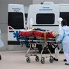 Nhân viên y tế chuyển bệnh nhân COVID-19 lên xe cứu thương tại Angers, Pháp ngày 15/3/2021. (Nguồn: AFP/TTXVN) 