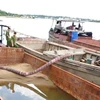 Các đối tượng sử dụng thuyền, tàu để khai thác cát trái phép trên các tuyến sông trên địa bàn huyện Quảng Ninh, Quảng Bình. (Nguồn: TTXVN phát) 