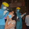 Nhân viên y tế quận Hải Châu khẩn trương lấy mẫu xét nghiệm người dân ngay trong đêm. (Ảnh: Văn Dũng/TTXVN) 