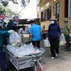 Các tình nguyện viên chuyển thực phẩm lên xe để đi phân phát cho các hộ dân tại xã Mão Điền. (Ảnh: Thanh Thương/ TTXVN) 