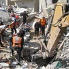 Lực lượng dân phòng Palestine tìm kiếm các nạn nhân dưới những căn nhà bị sập sau vụ không kích của máy bay Israel xuống thành phố Gaza, ngày 16/5/2021. (Nguồn: THX/TTXVN) 