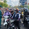 Lực lượng chức năng hướng dẫn người dân khai báo y tế tại chốt kiểm soát giao lộ Phan Văn Trị-Phạm Văn Đồng. (Nguồn: TTXVN phát) 