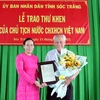 Phó Chủ tịch Ủy ban Nhân dân tỉnh Sóc Trăng Huỳnh Thị Diễm Ngọc trao thư khen của Chủ tịch nước cho ông Trần Cang. (Ảnh: Trung Hiếu/TTXVN) 