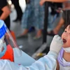 Nhân viên y tế lấy mẫu xét nghiệm COVID-19 cho người dân tại tỉnh Hồ Nam, Trung Quốc. (Ảnh: THX/TTXVN) 