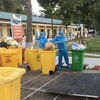 Các nhân viên Công ty Cổ phần Nước-Môi trường Bình Dương (Biwase) thu gom rác thải y tế ở các khu điều trị bệnh nhân COVID-19. (Ảnh: Huyền Trang/TTXVN) 