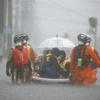 Nhân viên cứu hộ sơ tán người dân khỏi khu vực ngập lụt do mưa lớn ở thành phố Kurume, tỉnh Fukuoka, miền Tây Nam Nhật Bản, ngày 14/8/2021. (Ảnh: Kyodo/TTXVN) 
