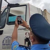 Thanh tra Giao thông tỉnh Kon Tum kiểm tra mã QR Code trên thẻ nhận diện hoạt động luồng xanh của các phương tiện vận tải tại các chốt ra, vào tỉnh. (Ảnh: Dư Toán/TTXVN) 