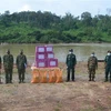 Đại diện Đồn biên phòng Ia O, Bộ chỉ huy biên phòng tỉnh Gia Lai (bên trái) trao hỗ trợ lương thực, thực phẩm, nhu yếu phẩm và vật tư y tế hỗ trợ công tác phòng, chống dịch cho đại diện lực lượng bảo vệ biên giới Campuchia. (Ảnh: Hồng Điệp/TTXVN) 