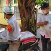 Đảng viên chi bộ khu dân cư Xuân Đán 5 tham gia Ban điều hành dân phố vận chuyển gạo đi phát cho hộ dân trong khu dân cư. (Ảnh: Trần Lê Lâm/TTXVN) 