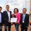 Đại sứ Việt Nam tại Đức, ông Nguyễn Minh Vũ (thứ 2 từ trái sang) tiếp nhận số tiền quyên góp của cộng đồng người Việt ở thành phố Rostock và vùng phụ cận. (Ảnh: Mạnh Hùng/TTXVN) 