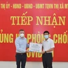 Ông Urs Kloeti, Giám đốc nhà máy Nestlé Bông Sen tại Hưng Yên, trao quà cho lãnh đạo thị xã Mỹ Hào để tiếp sức cho người dân bị ảnh hưởng bởi dịch COVID-19. (Ảnh: Đinh Tuấn/TTXVN) 