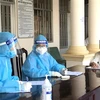 Các nữ nhân viên y tế tư vấn cho người dân trước khi tiêm vaccine phòng COVID-19. (Ảnh: Lê Thúy Hằng/TTXVN) 