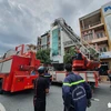 Lực lượng phòng cháy chữa cháy điều xe thang đến hiện trường dập lửa. (Nguồn: tuoitre.vn) 
