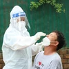 Nhân viên y tế lấy mẫu xét nghiệm cho người dân thành phố Buôn Ma Thuột. (Ảnh: Tuấn Anh/TTXVN) 