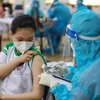 Nhân viên y tế tiêm vaccine phòng COVID-19 cho học sinh tại huyện Củ Chi. (Ảnh: Thu Hương/TTXVN) 