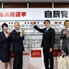Thủ tướng Nhật Bản, Chủ tịch LDP Fumio Kishida gắn hoa bên cạnh tên của những ứng cử viên trúng cử trong cuộc bầu cử Hạ viện tại Tokyo ngày 31/10/2021. (Ảnh: AFP/TTXVN) 