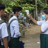 Kiểm tra thân nhiệt cho học sinh để phòng dịch COVID-19 tại trường học ở Sittwe, bang Rakhine, Myanmar, ngày 1/6/2021. (Ảnh: AFP/TTXVN) 
