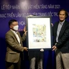 Đại diện họa sỹ Vĩnh Khoa (bên phải) trao tặng hiện vật tranh cho Bảo tàng Mỹ thuật Đà Nẵng tại buổi lễ. (Ảnh: Trần Lê Lâm/TTXVN) 