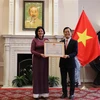 Đại sứ Việt Nam tại Mỹ Hà Kim Ngọc trao tặng Huân chương Hữu nghị cho Đại sứ Lianys Torres Rivera. (Ảnh: Phạm Ngọc Ánh/TTXVN) 