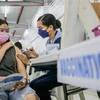 Nhân viên y tế tiêm vaccine phòng COVID-19 cho học sinh tại Marikina, Philippines, ngày 29/11/2021. (Ảnh: THX/TTXVN) 