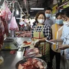 Kiểm tra chứng từ chứng minh nguồn gốc thực phẩm của tiểu thương tại chợ Phạm Văn Hai, Thành phố Hồ Chí Minh. (Ảnh: Hồng Giang/TTXVN) 