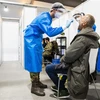 Nhân viên y tế lấy mẫu xét nghiệm COVID-19 cho người dân tại Almere, Hà Lan ngày 3/12/2021. (Ảnh: AFP/TTXVN) 