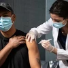 Nhân viên y tế tiêm vaccine phòng COVID-19 cho người dân tại New York, Mỹ. (Ảnh: AFP/TTXVN) 