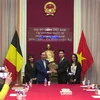 Đại sứ Nguyễn Văn Thảo tặng hoa cho Tân Chủ tịch Hội Sinh viên Việt Nam tại Bỉ. (Ảnh: Đức Hùng/Vietnam+) 