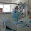 Nhân viên y tế điều trị cho bệnh nhân COVID-19. (Ảnh: AFP/TTXVN) 
