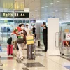 Những du khách Việt Nam đầu tiên nhập cảnh qua làn VTL vào Singapore ngày 16/3. (Ảnh: Lê Dương/TTXVN) 