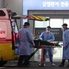 Nhân viên y tế chuyển bệnh nhân COVID-19 tới bệnh viện tại Seoul, Hàn Quốc, ngày 22/3/2022. (Ảnh: THX/TTXVN) 