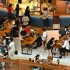 Người dân dùng bữa tại một nhà hàng trong trung tâm thương mại ở Singapore. (Ảnh: AFP/TTXVN) 
