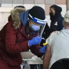 Nhân viên y tế tiêm vaccine phòng COVID-19 cho người dân tại Toronto, Canada, ngày 28/3/2022. (Ảnh: THX/TTXVN) 