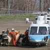 Lực lượng cứu hộ chuyển nạn nhân trong vụ chìm tàu du lịch từ trực thăng cứu hộ tới xe cứu thương tại đảo Hokkaido, Nhật Bản ngày 24/4. (Ảnh: AFP/TTXVN) 
