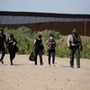 Lực lượng chức năng Mỹ bắt giữ người di cư bất hợp pháp vượt biên từ Mexico vào Mỹ tại Yuma, bang Arizona ngày 12/5/2021. (Ảnh: AFP/TTXVN) 
