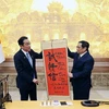 Thủ tướng Phạm Minh Chính tặng Thủ tướng Nhật Bản Kishida Fumio bức thư pháp "Chân thành-Tình cảm-Tin cậy." (Ảnh: Dương Giang/TTXVN) 