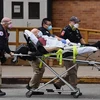 Nhân viên y tế chuyển bệnh nhân COVID-19 vào bệnh viện tại New York, Mỹ. (Ảnh: AFP/TTXVN) 