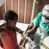 Nhân viên y tế xét nghiệm máu cho em nhỏ tiếp xúc với bệnh nhân mắc đậu mùa khỉ tại Zomea Kaka, Cộng hòa Trung Phi, ngày 18/10/2018. (Ảnh: AFP/TTXVN) 