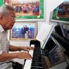 Ông Duangmixay Likaya thể hiện tác phẩm bản giao hưởng Hồng Hà-Mekong. (Ảnh: Phạm Kiên/TTXVN) 