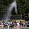 Người dân làm mát tại đài phun nước do nắng nóng gay gắt ở London, Anh ngày 17/6/2022. Theo Văn phòng khí tượng Anh, 50% khả năng nhiệt độ nước này trong ngày 18 và 19/7 sẽ lần đầu tiên vượt 40 độ C. (Ảnh: AFP/TTXVN) 