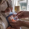 Tiêm vaccine phòng COVID-19 cho trẻ nhỏ. (Ảnh: AFP/TTXVN) 