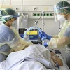 Nhân viên y tế điều trị cho bệnh nhân COVID-19. (Ảnh: AFP/ TTXVN) 