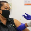 Nhân viên y tế tiêm vaccine phòng COVID-19 cho người dân tại Sydney, Australia. (Ảnh: AFP/TTXVN) 