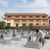 Ông Vinh (tóc dài) thắp hương cho các liệt sỹ tại Nghĩa trang Liệt sỹ xã Ninh Hải. (Ảnh: Hải Yến/TTXVN) 