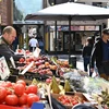 Khách hàng mua sắm tại một chợ rau quả ở London, Anh. (Ảnh: AFP/TTXVN) 